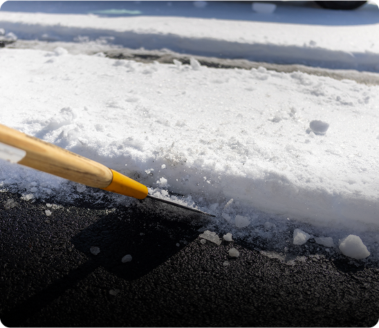 Shoveling snow from a paved surface.